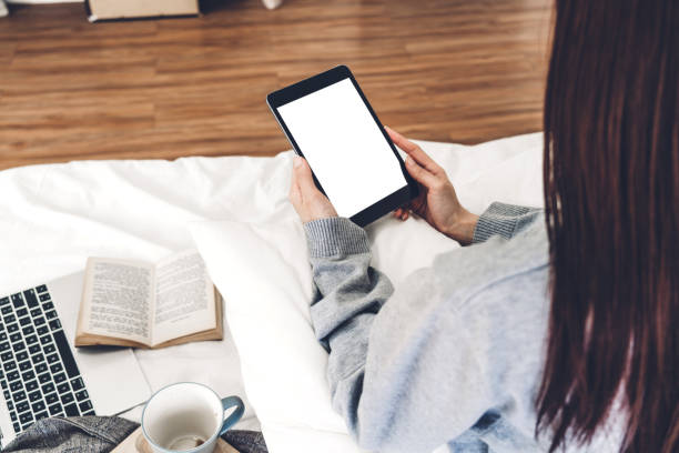 istock Woman relaxing and using digital tablet computer with white mockup blank screens on the bed at home.woman checking social apps and working..Communication and technology concept 1158195543