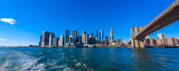 famoso skyline del centro de la ciudad de nueva york, brooklin bridge y manhattan con rascacielos iluminados sobre el panorama de east river. nueva york, estados unidos - manhattan dusk new york state sunrise fotografías e imágenes de stock