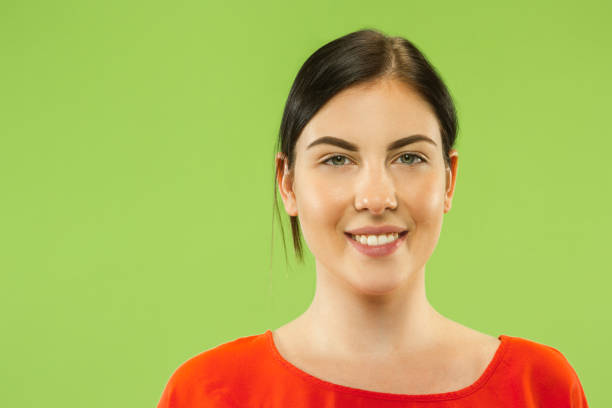 istock Caucasian young woman's close up portrait on green background 1158196331