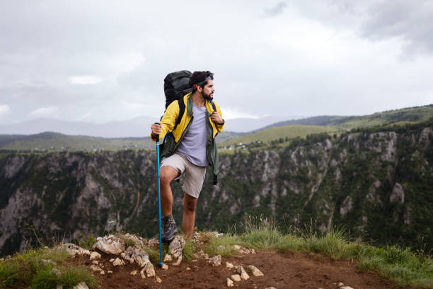 istock Young man traveling with backpack hiking in mountains 1158196989