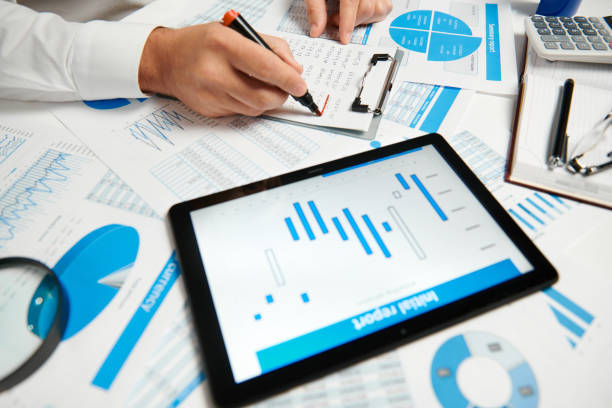 istock Businessman working and calculating, reads and writes reports. Using tablet pc. Office employee, table closeup. Business financial accounting concept. 1158197150