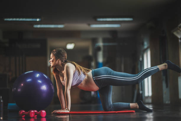 istock Pregnant young woman exercising on  mat in studio 1158197471