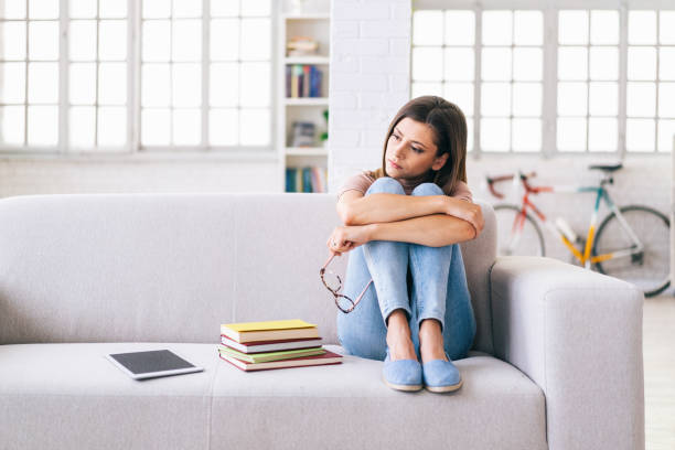 istock Tired woman sitting on a sofa at home 1158199746