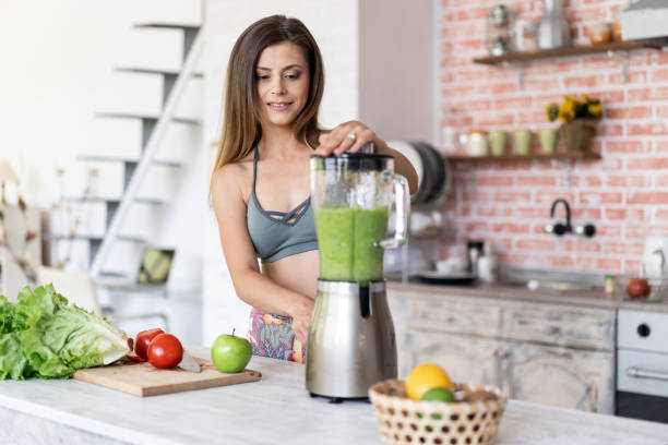istock Smiling sporty woman making smoothie 1158200390