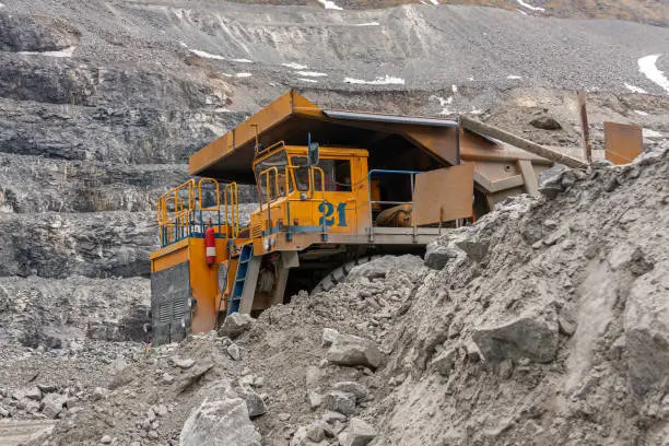 Gigat dump trucks are working in the mine for the production of apatite in the Murmansk region carrying rock. Extraction of minerals in the harsh highlands.