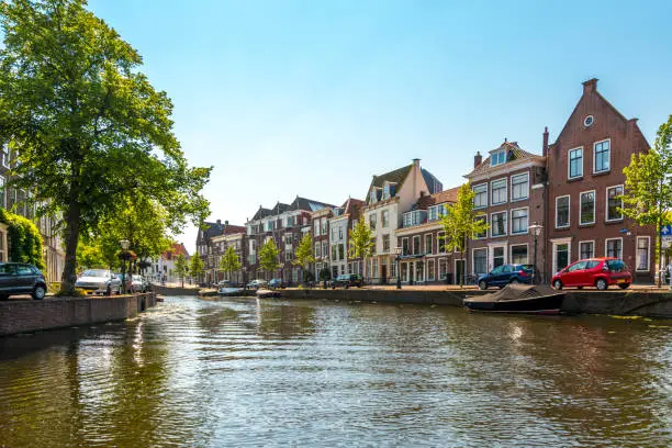 City of Leiden with his canals in early morning sun. Shot from the water, view on the Rapenburg. canals with historical houses in the dutch city of Leiden. Birthplace of Rembrandt van Rijn.
