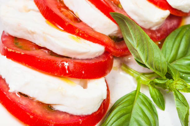 istock sliced mozzarella and tomato with basil close up 1158204156