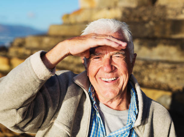 istock Handsome senior man shields his eyes against bright morning sun 1158207580