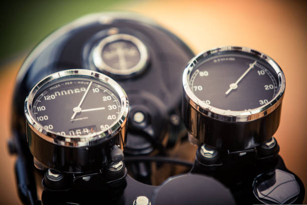 Close up horizontal image of the speedometer and tachometer gauges of a vintage motorcycle.