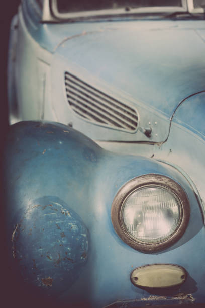 Close up vertical image of the headlight of a blue vintage classic car.