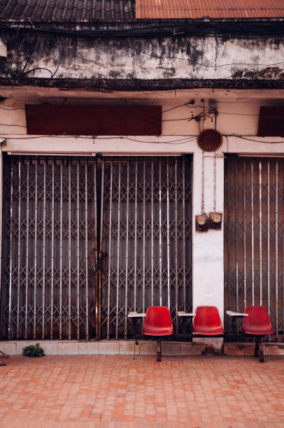 Old retro red lecture row seats and old rustic building with metal gate