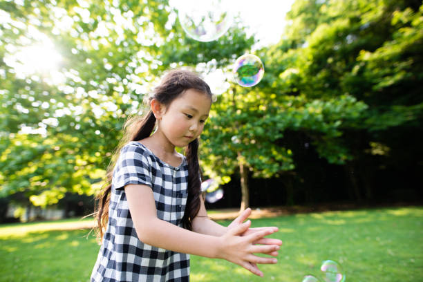 istock Girl playing with soap bubbles 1158210690