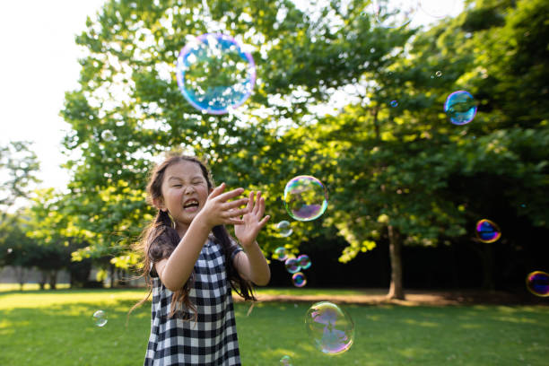 istock Girl playing with soap bubbles 1158210710