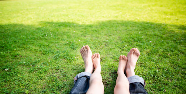 istock Father and daughter feet sitting on the grass 1158210713