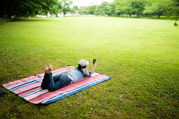 istock Woman looking at a smartphone in the park 1158212434