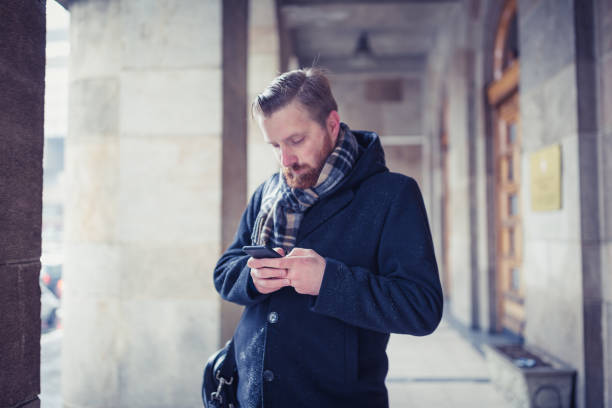 istock Ginger businessman texting outdoors on a snowy day 1158213879