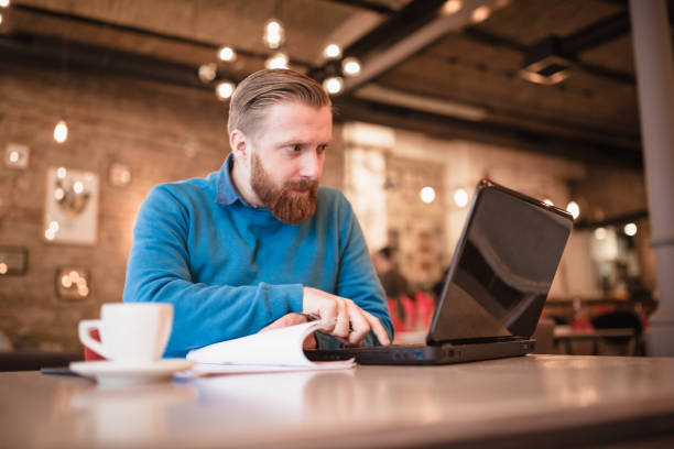 istock Young, redhead businessman, on coffee break working on laptop 1158213902
