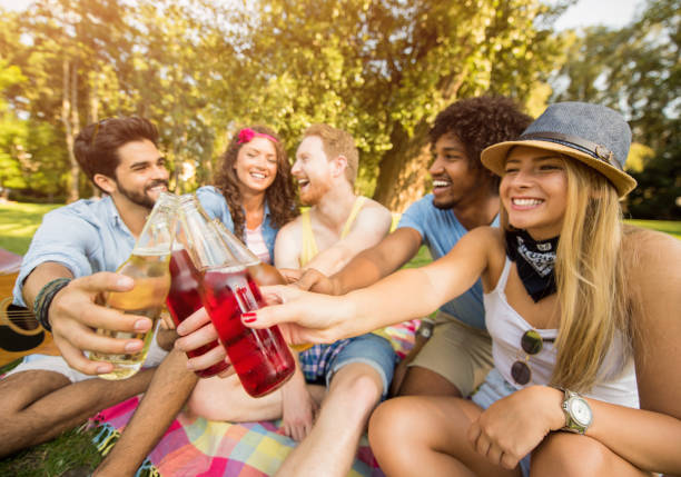 istock Happy young people toasting with drinks outdoors. 1158214146