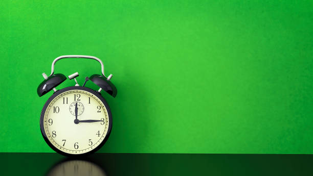 istock Vintage alarm clock on green background 1158215239