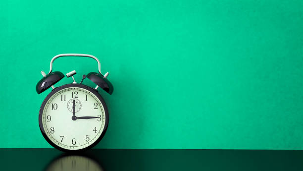 istock Vintage alarm clock on green background 1158215270