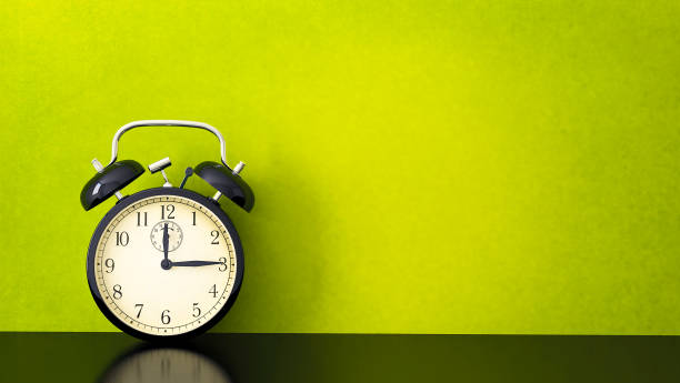 istock Vintage alarm clock on yellow background 1158215304