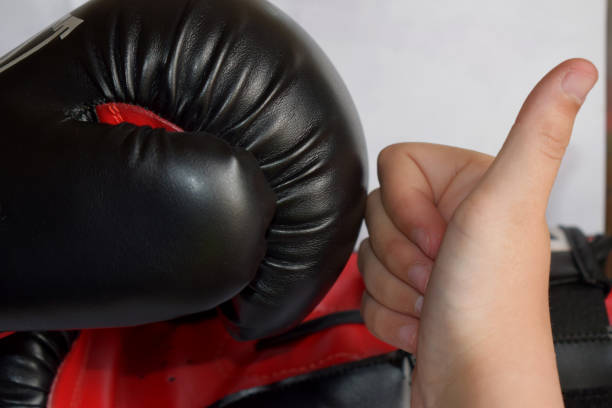 istock young hand and a black boxing glove 1158215517