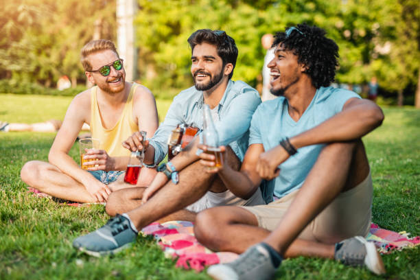 istock Three young men resting and drinking on a music festival. 1158216595