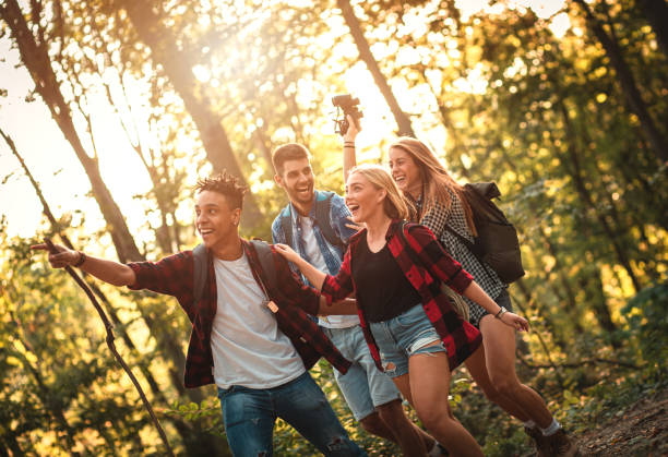 istock Group of four friends having fun hiking through forest together. 1158217320