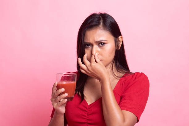 istock Young Asian woman hate tomato juice. 1158219134