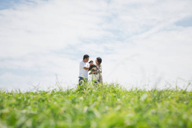 istock Asian couple with dog relaxed on grass under blue sky 1158219468