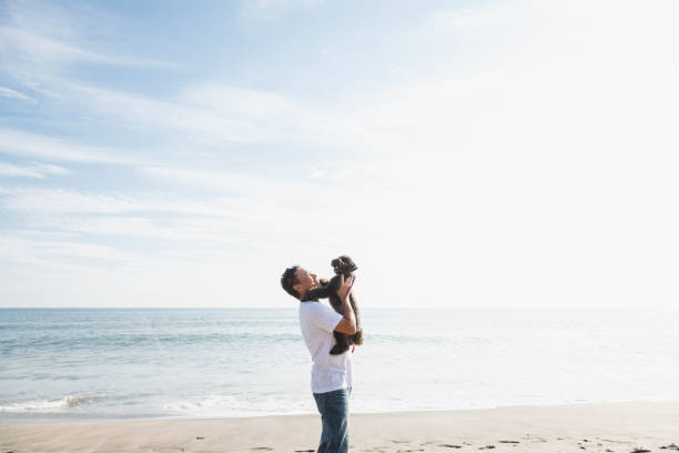 istock Asian man with dog relaxed in the beach 1158220085