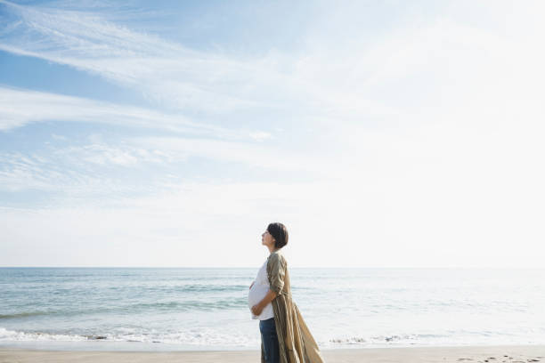 Asian pregnant woman relaxed outdoors.