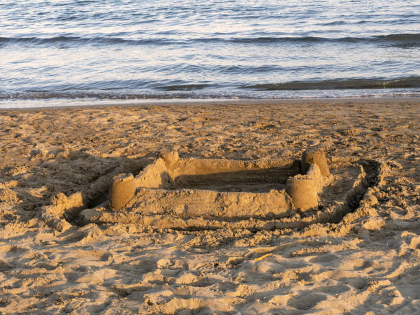 istock Sunset sandcastle on the beach. Holidays, vacation over concept. Rudimentry construction With copyspace. 1158220350