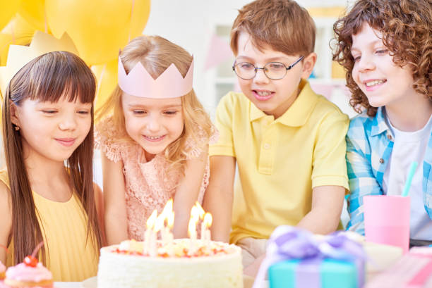 istock Happy kids with birthday cake blowing candles 1158220676