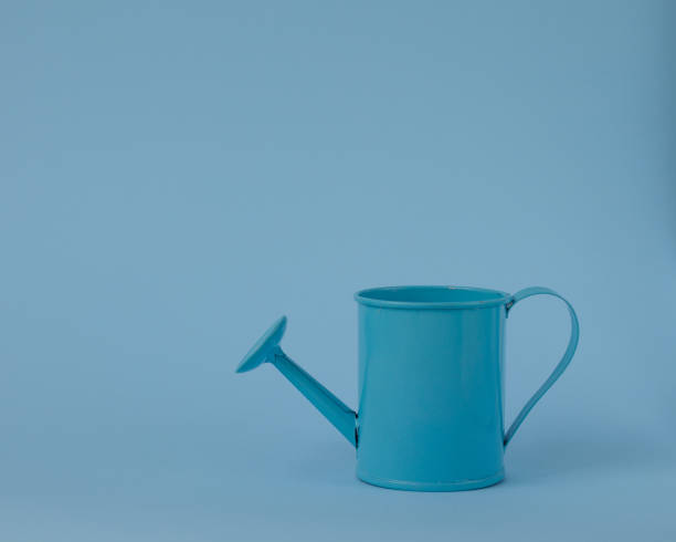 istock Toy blue watering can against a blue background. 1158222137