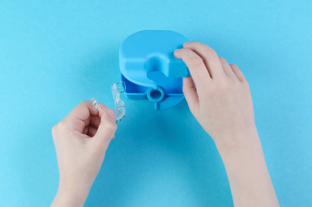 istock child's hand with orthodontic appliance with box on blue background 1158222315