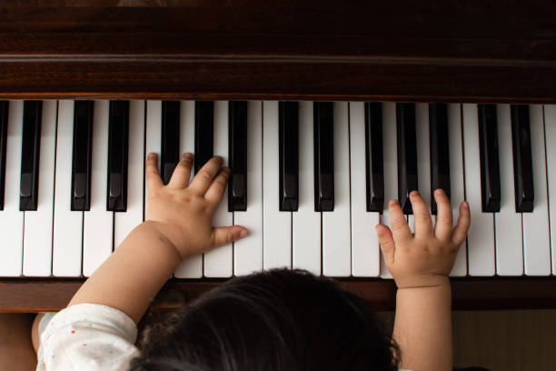 istock the baby's hand and piano keyboard 1158223303