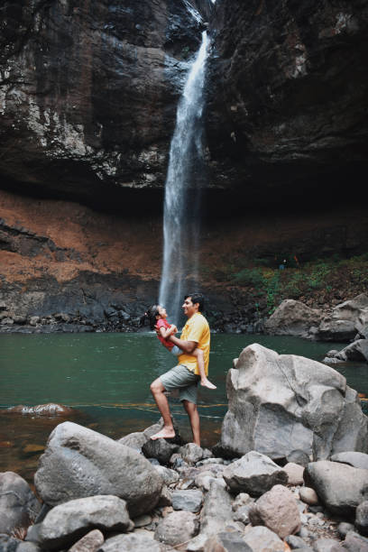 istock Father and daughter having fun at waterfall 1158224025