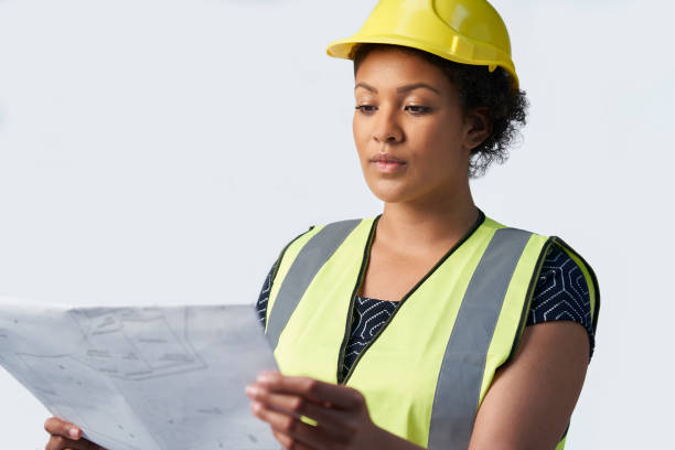 istock Studio Shot Of Female Architect With Studying Plans Against White Background 1158225160