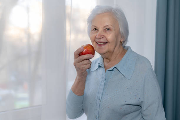 istock An elderly woman is going to eat an Apple 1158225331