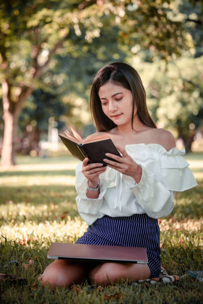 istock One women in Public park drink coffee and read a book 1158225435