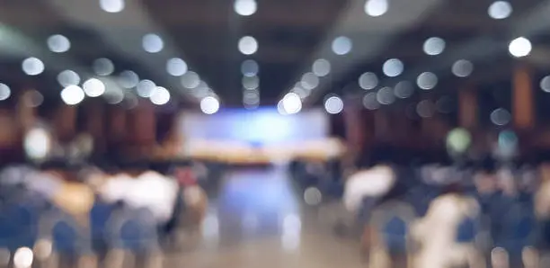 Photo of blurred people sitting at the conference