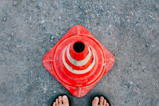 top view traffic cone, with white and orange stripes on the road