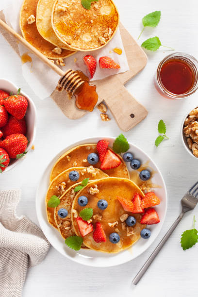 pancakes with blueberry strawberry honey and nuts for breakfast - norway maple imagens e fotografias de stock