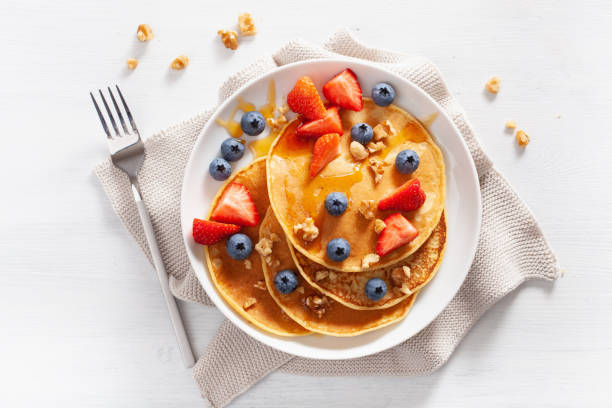 pancakes with blueberry strawberry honey and nuts for breakfast - norway maple imagens e fotografias de stock