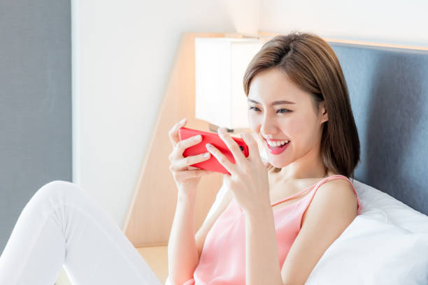 istock woman play mobile game happily 1158231318