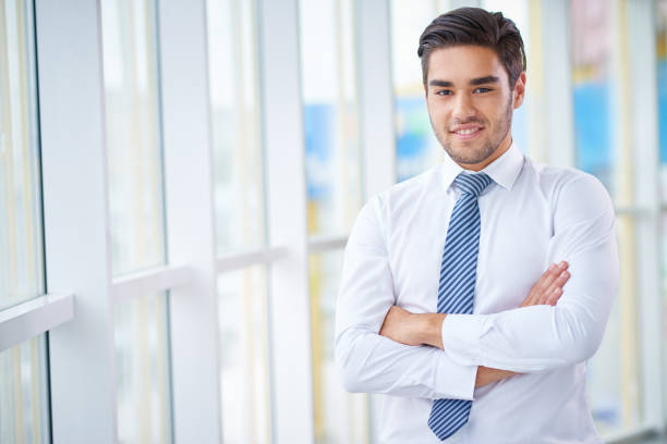 istock Young smiling businessman with arms crossed 1158231336