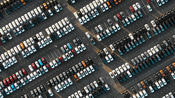 Aerial view of the parked new cars at the automotive plant fantastic flight over parked new cars at the car building enterprise at sunset, smooth rows of cars automobile industry stock pictures, royalty-free photos & images