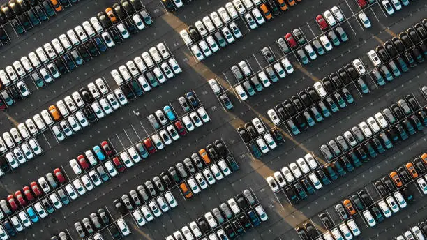 fantastic flight over parked new cars at the car building enterprise at sunset, smooth rows of cars