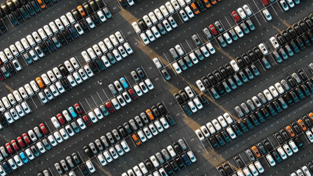 вид с воздуха на припаркованные новые автомобили на автомобильном заводе - mass transportation стоковые фото и изображения